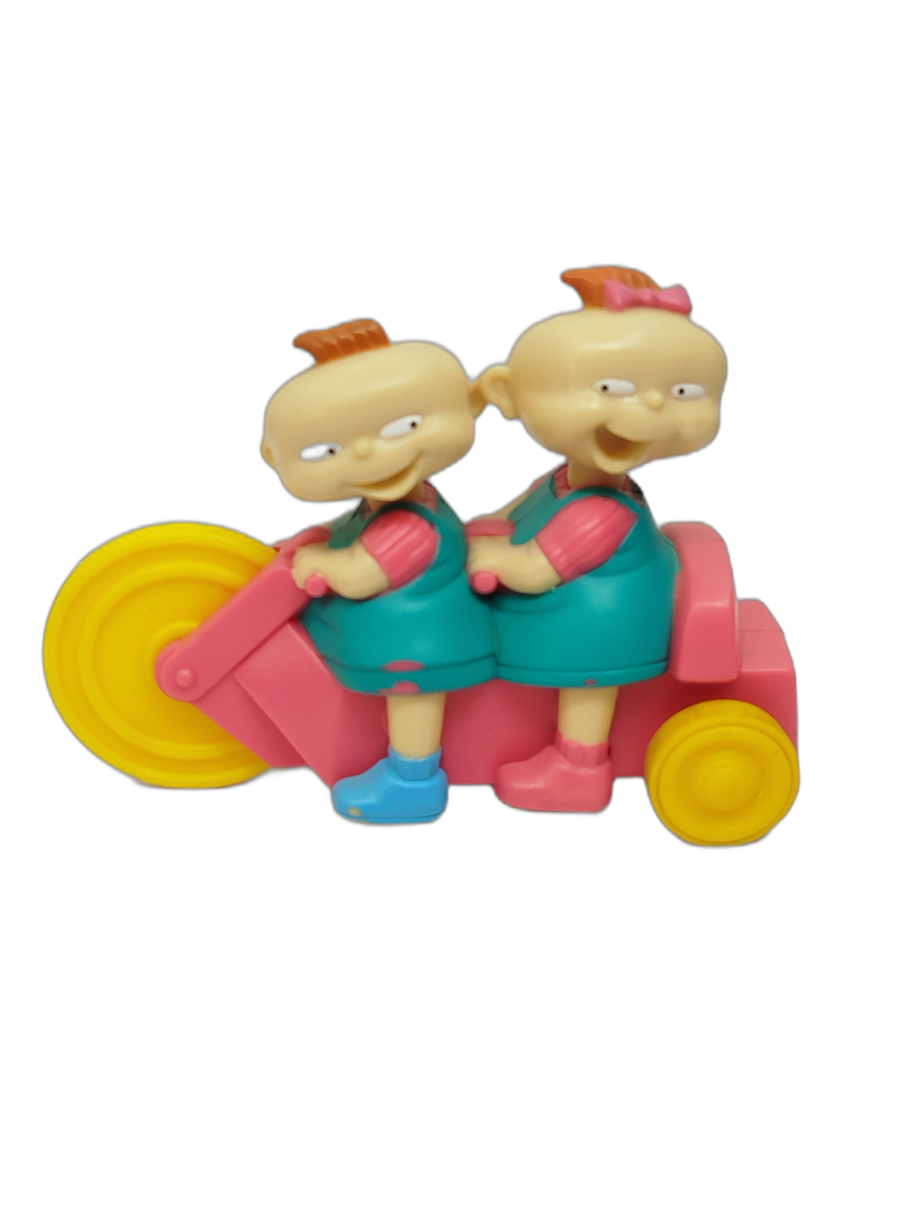 gemelos Phili y Lili (Phil and Lil DeVille) montados en su triciclo tándem de color rosado con ruedas amarillas