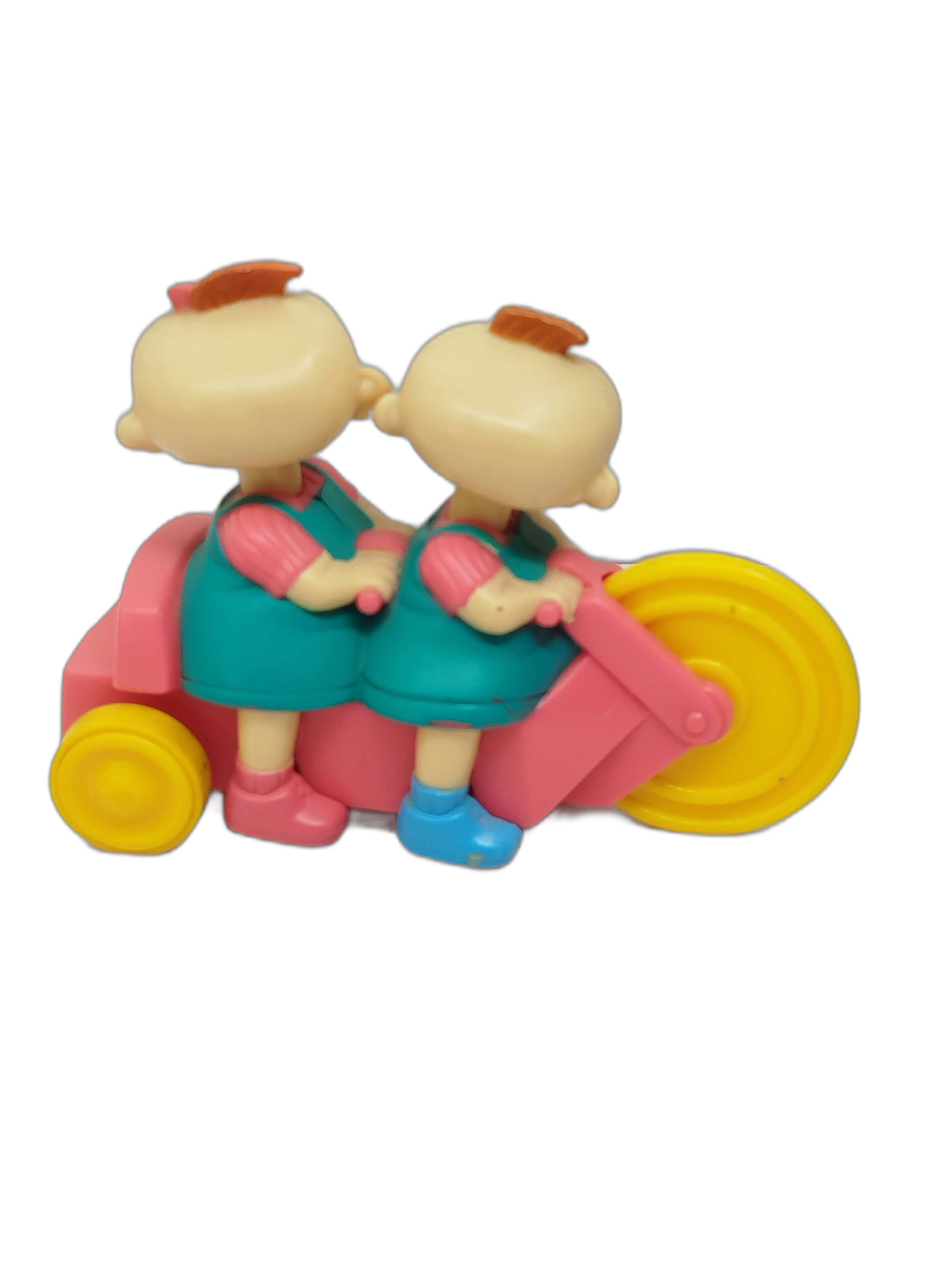 gemelos Phili y Lili (Phil and Lil DeVille) montados en su triciclo tándem de color rosado con ruedas amarillas