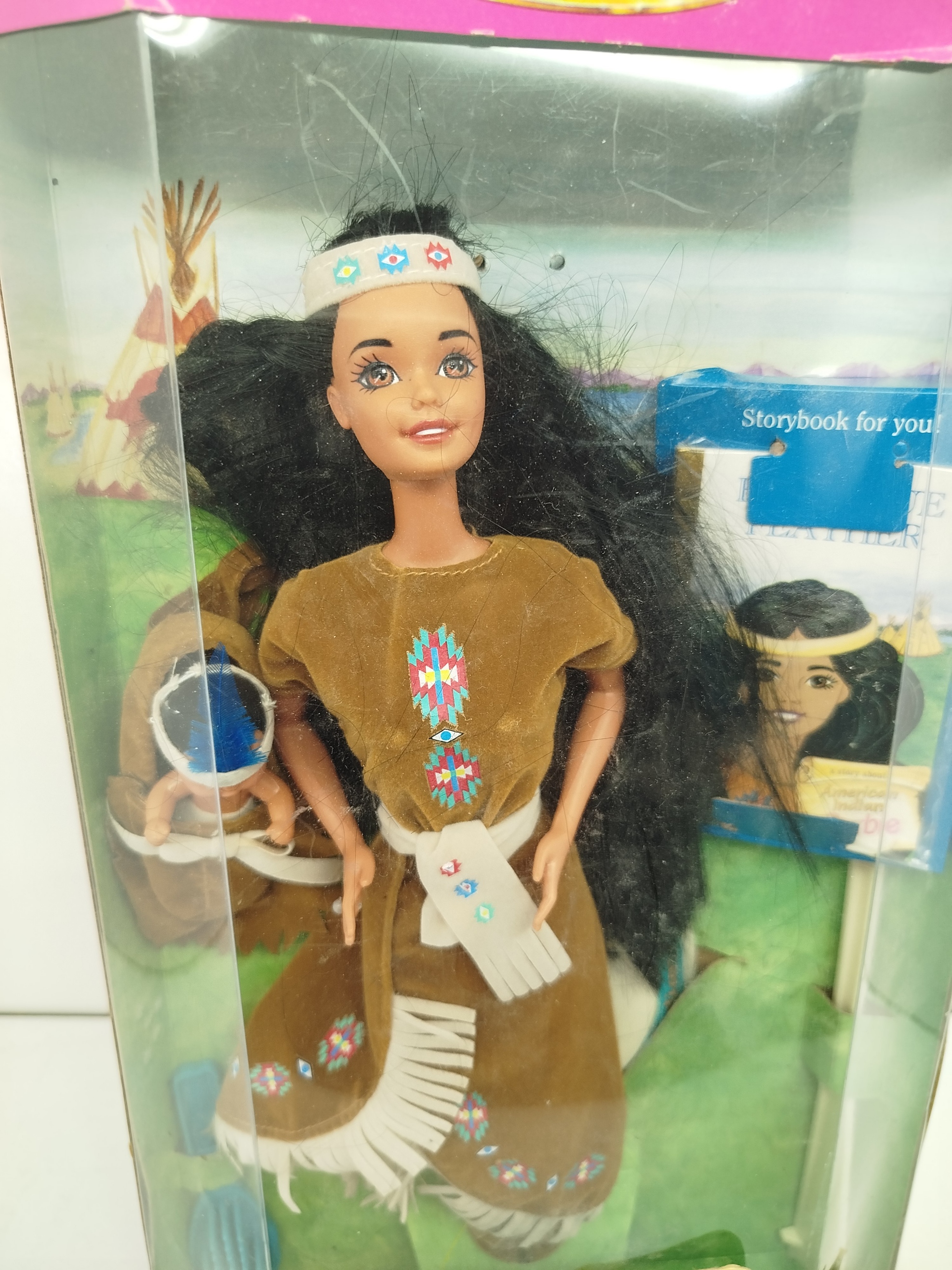 American Indian Barbie, vestido tradicional con flecos,  diadema  y a su prima pequeña Baby Blue Feather junto con un cuento