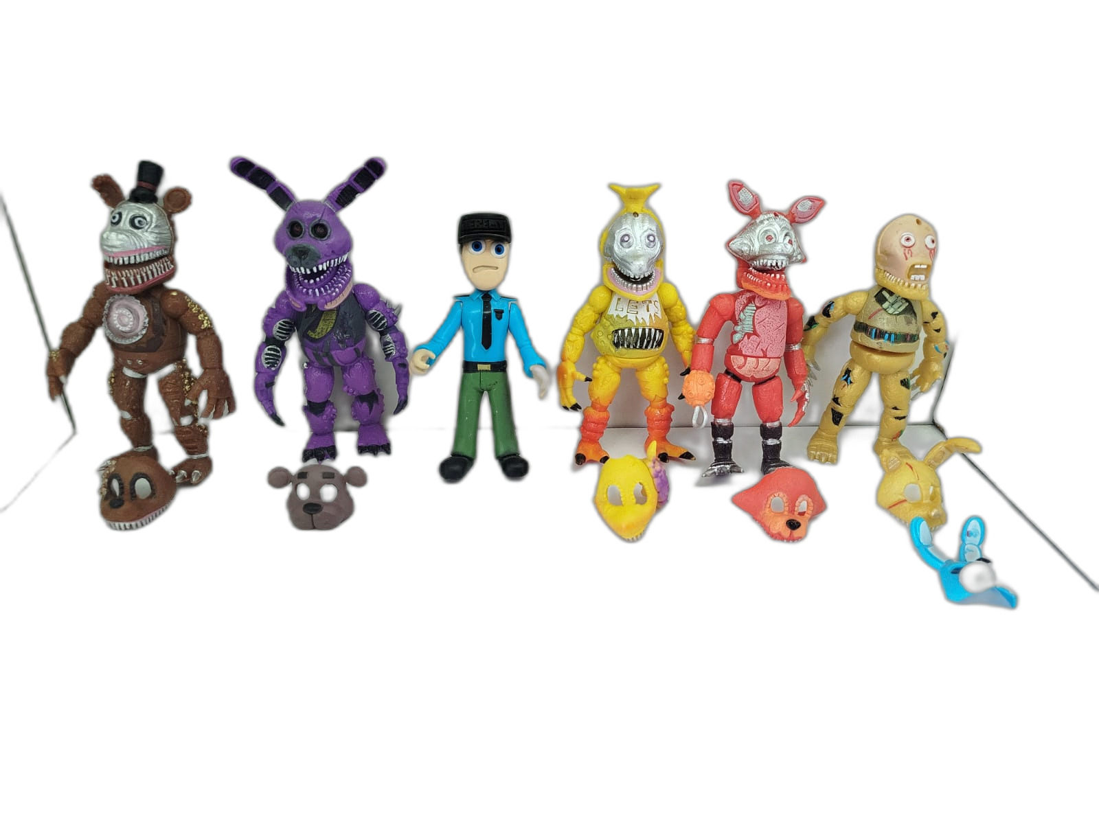 Five Nights at Freddy's - Nightmare Freddy, Nightmare Bonnie, un guardia de seguridad, Chica, Foxy y Springtrap, acompañados de cabezas o máscaras intercambiables
