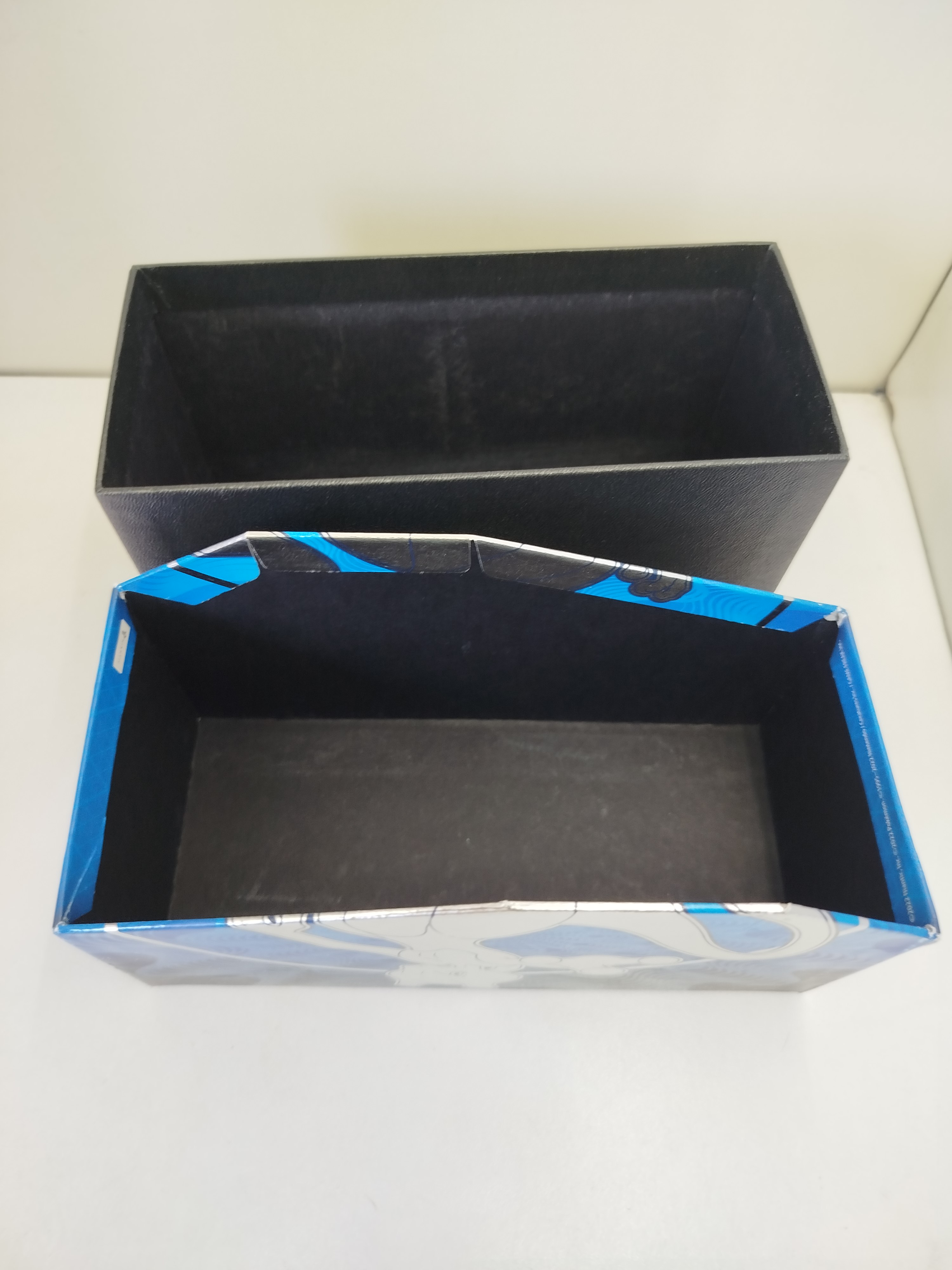 Pokemon - Caja de carton presenta un diseño galáctico y nocturno con la silueta y colores de Mewtwo, el Pokémon legendario que protagoniza este set conmemorativo del videojuego móvil