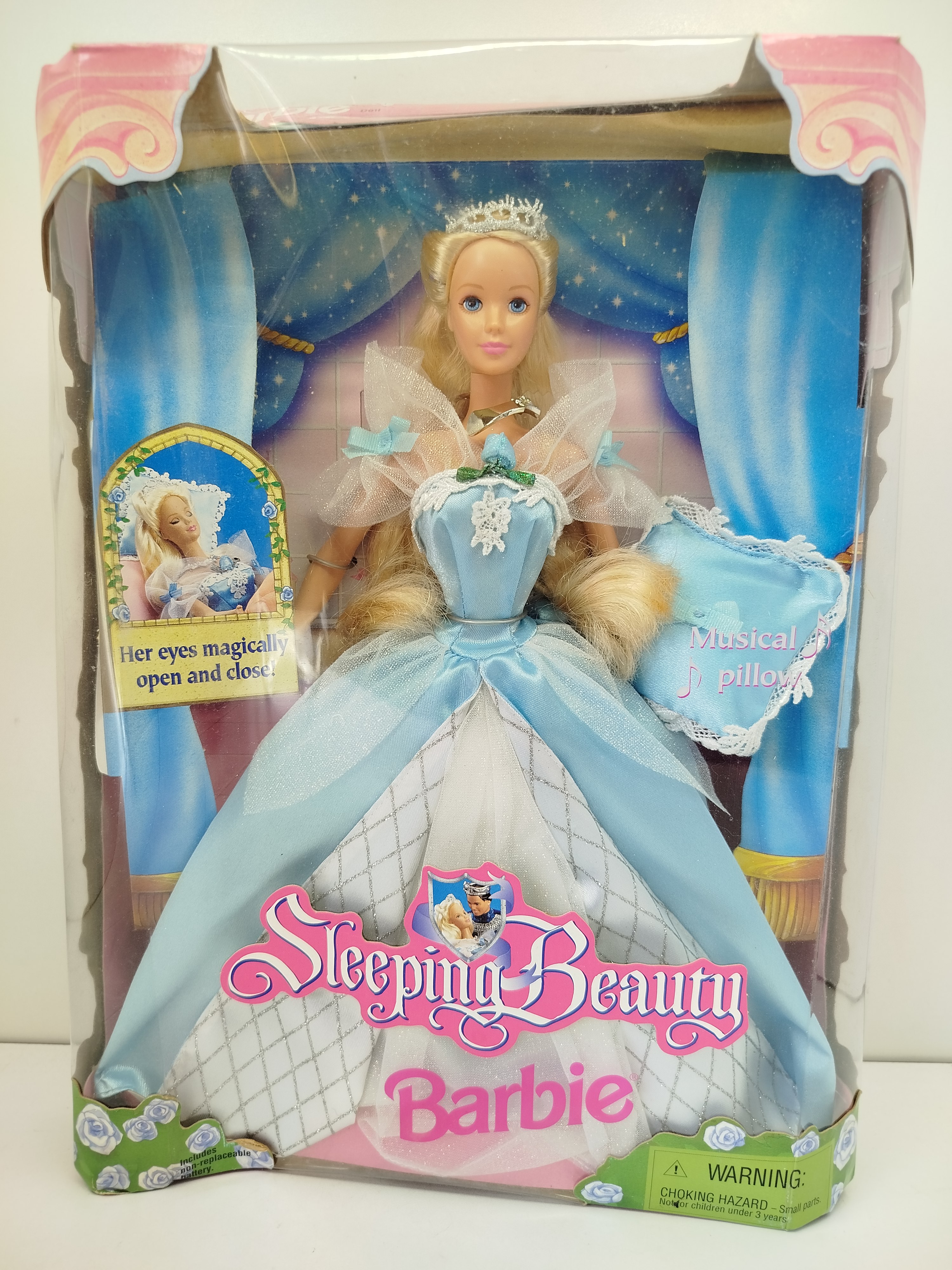 Barbie -  Sleeping Beauty Barbie (La Bella Durmiente) lanzada al mercado en 1998, célebre por incorporar un mecanismo en el brazo para abrir o cerrar sus ojos mágicamente y una almohada musical.