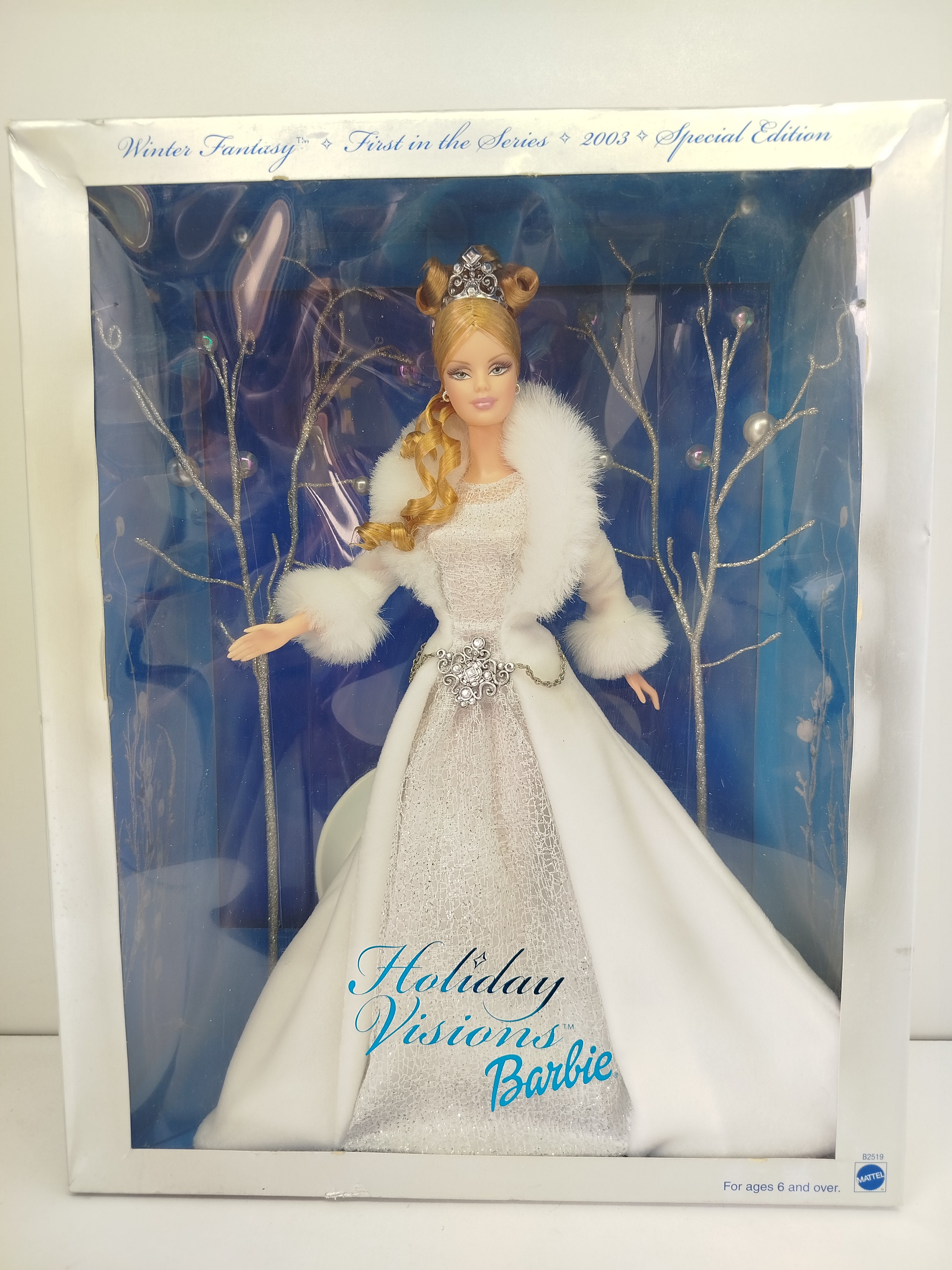 Barbie - Corresponde a la Winter Fantasy Barbie, la primera edición lanzada en el año 2003 para dar inicio a la icónica serie especial coleccionable Holiday Visions