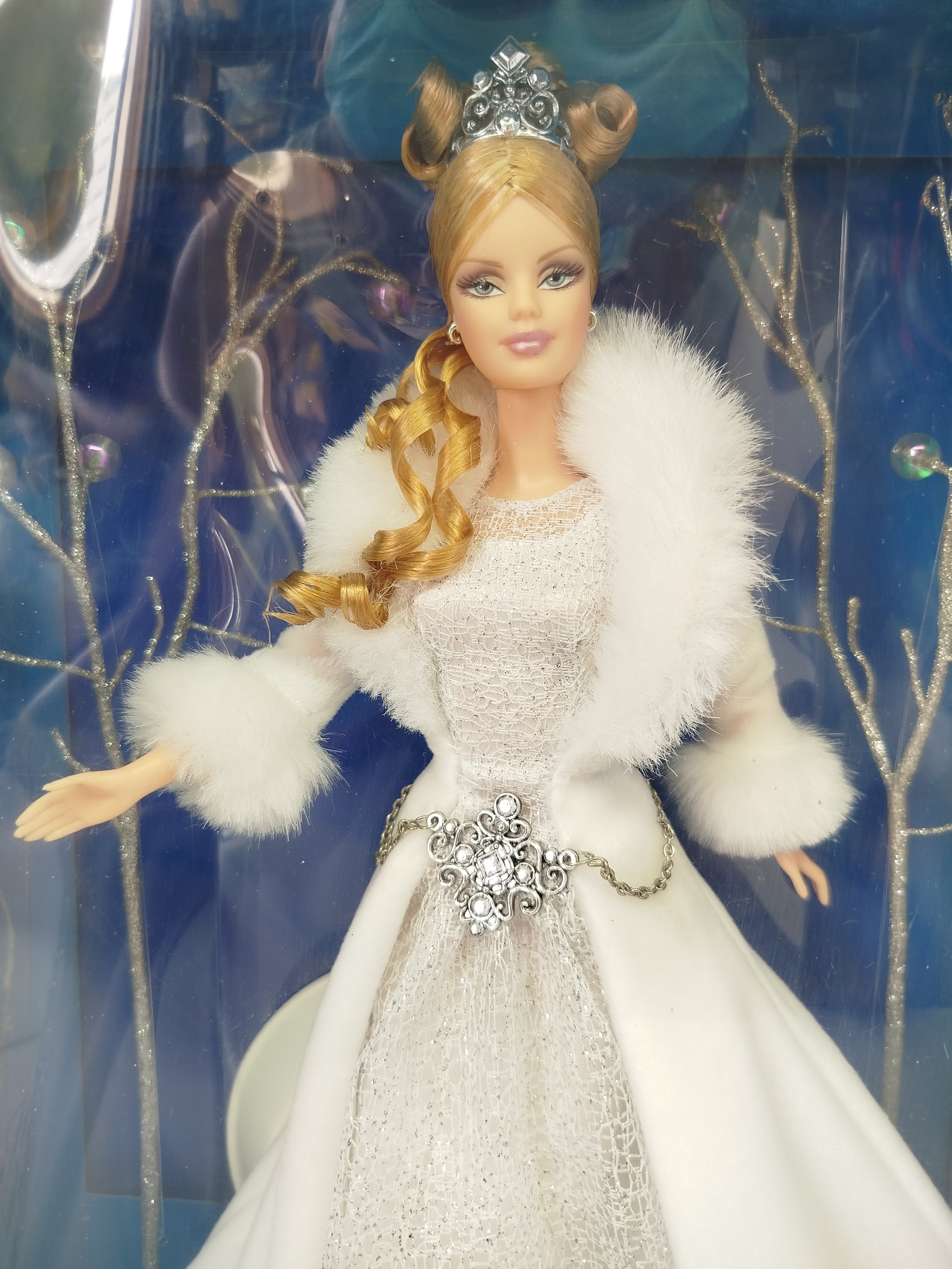 Barbie - Corresponde a la Winter Fantasy Barbie, la primera edición lanzada en el año 2003 para dar inicio a la icónica serie especial coleccionable Holiday Visions