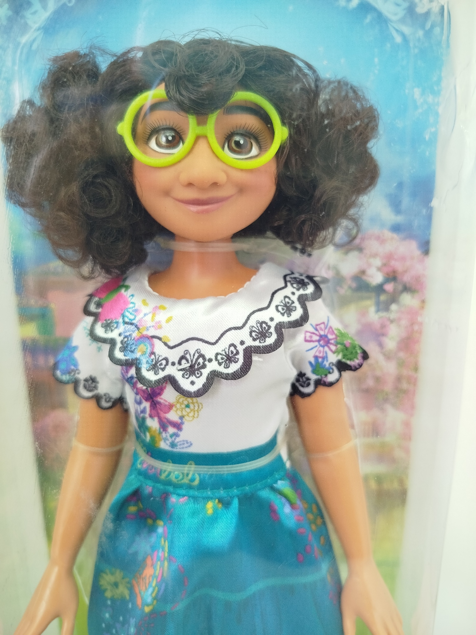 Disney Encanto Mirabel Madrigal Core Fashion Doll, la cual incluye su tradicional vestido folclórico con detalles impresos, sus icónicas gafas verdes y sus alpargatas magentas.