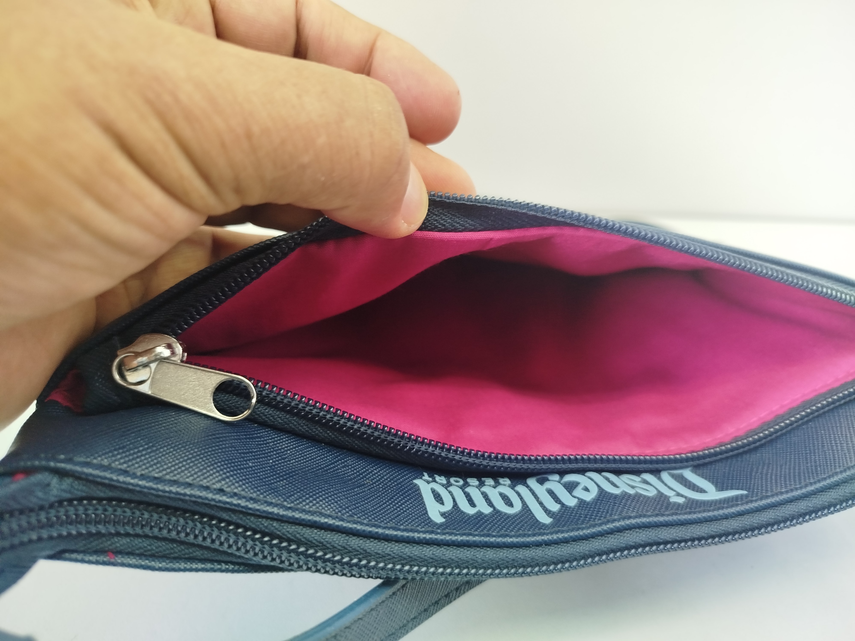 Bolso azul marino de Disneyland con  parches acolchados de atracciones icónicas como el castillo y la rueda de la fortuna en el frente
