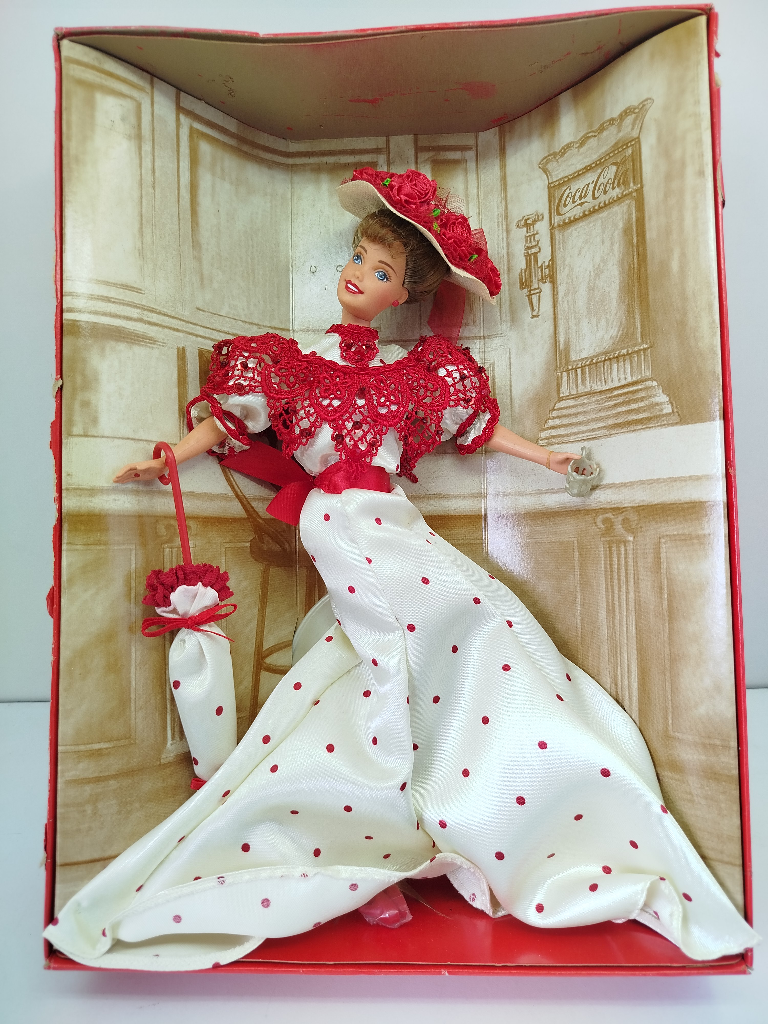 Soda Fountain Sweetheart Barbie, lanzada por Mattel en 1996 como la primera pieza de la serie Coca-Cola Fashion Classic Series - (CAJA CON DESGASTE)