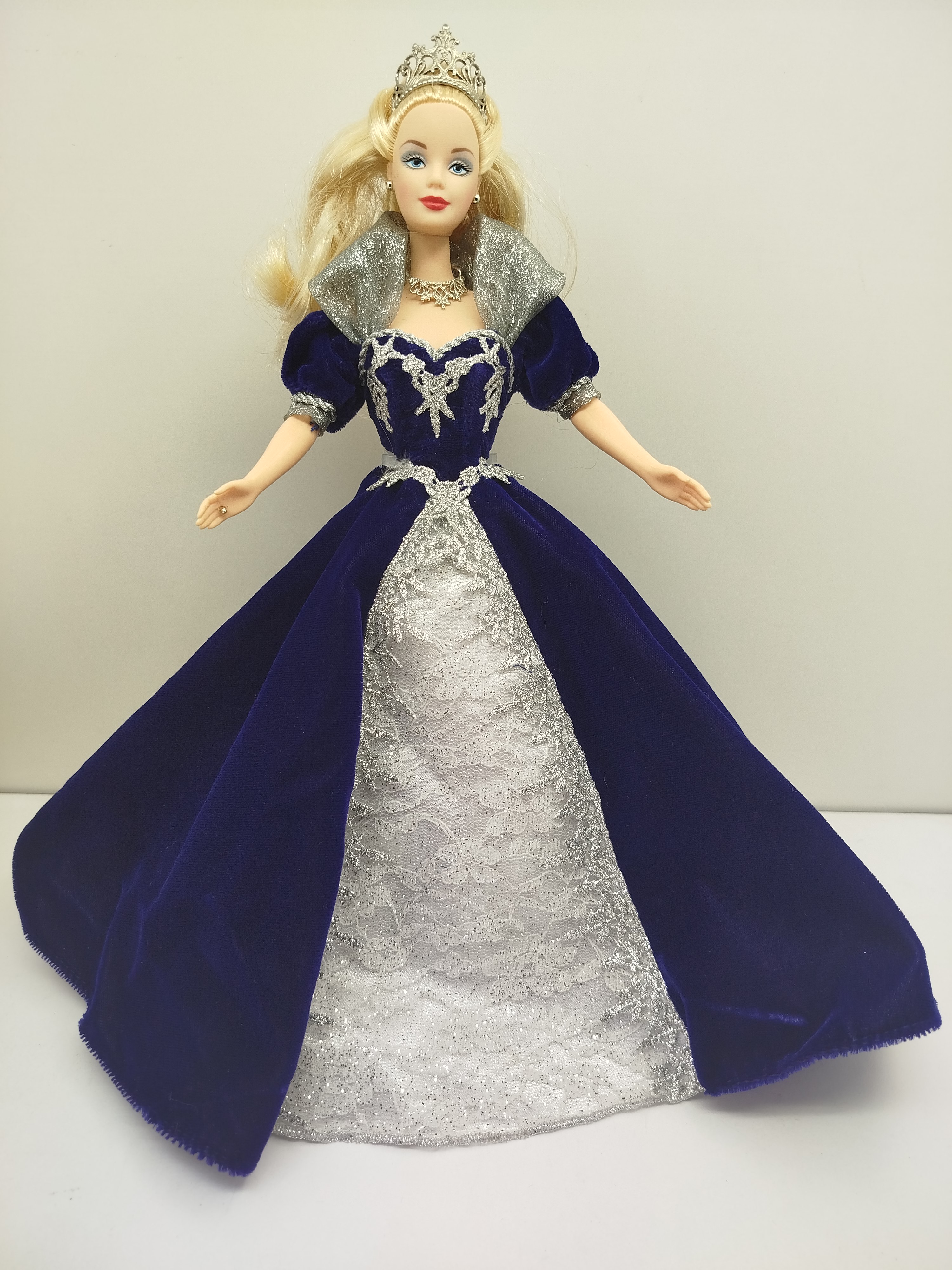 Millennium Princess Barbie de Mattel 2000 (con edición de 1999), la cual viste un elegante vestido de terciopelo azul oscuro con una sobrefalda plateada con encaje y destellos brillantes