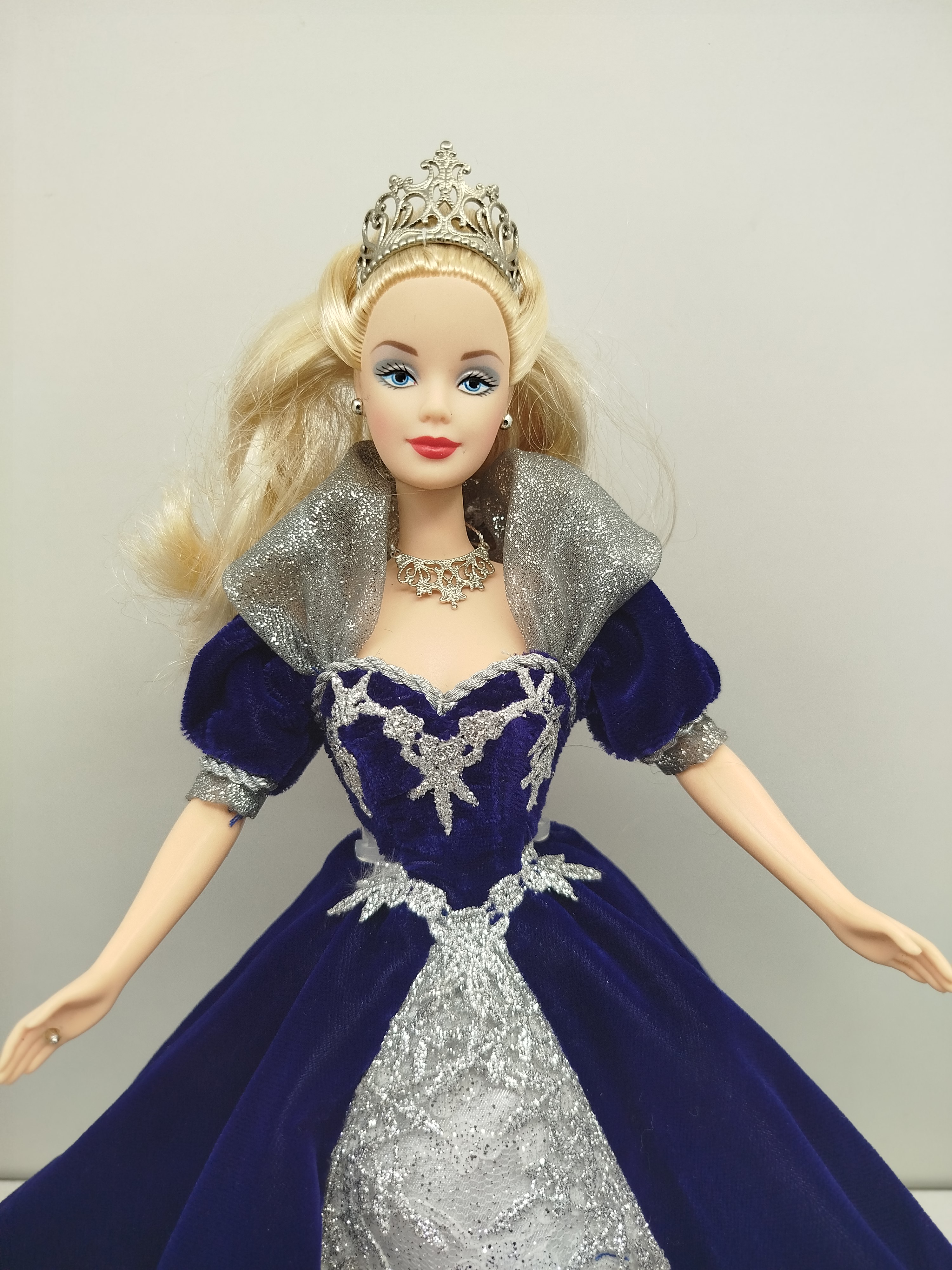 Millennium Princess Barbie de Mattel 2000 (con edición de 1999), la cual viste un elegante vestido de terciopelo azul oscuro con una sobrefalda plateada con encaje y destellos brillantes